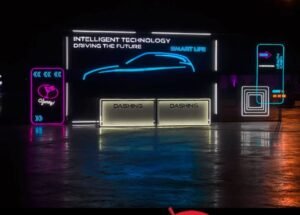 different type of signages showing , pink and blue led signages and white signages and a signage is written in intelligent technology driving the future and smart life and a blue car