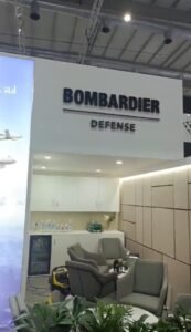 a business signage in a white background and in a black letter written in BOMBARIDER DEFENSE