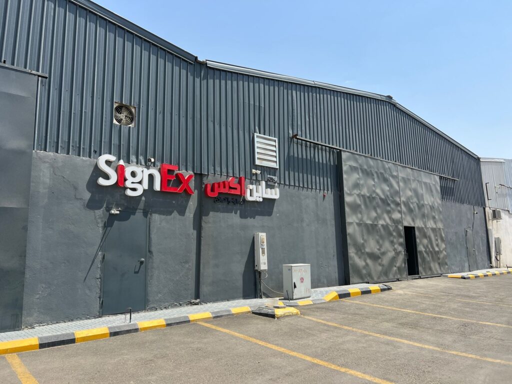 awhite and red signage written SIGNEX in arabi and english