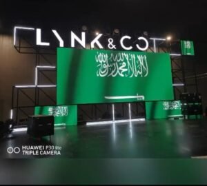 a green signage with white text and a letter signages in a exhibition stage