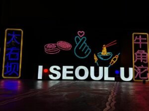 image shows i Seoul u in a white signage and colorful background signages